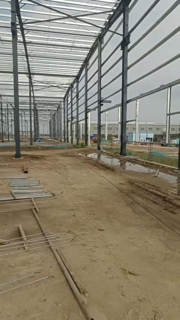 Vista interior de pórticos de estructura metálica alineados antes de la instalación de cerramientos.