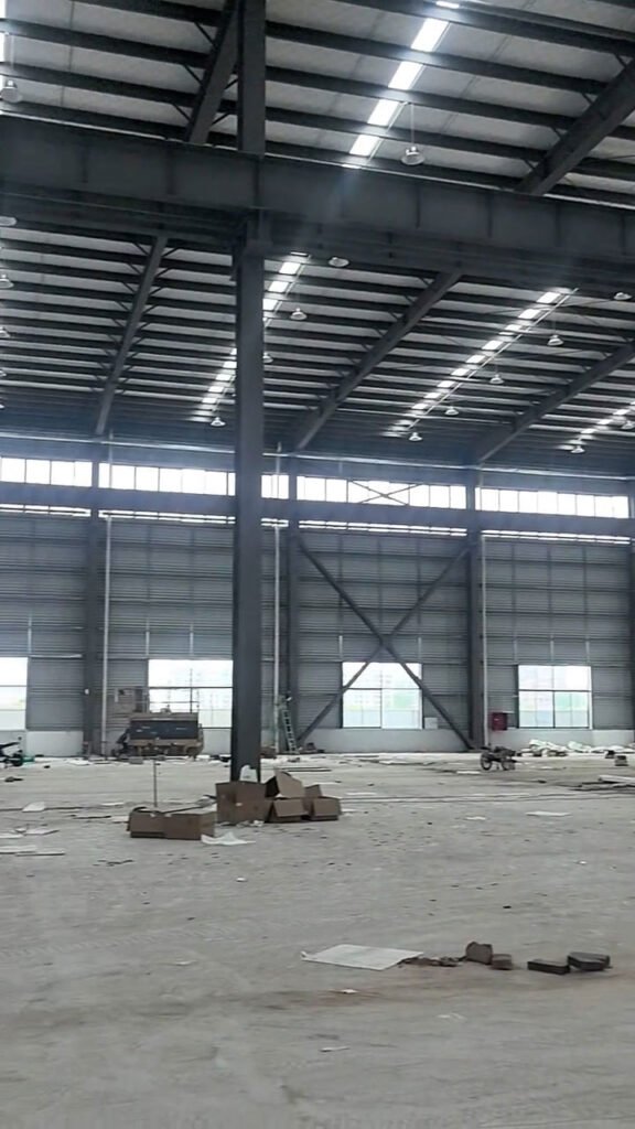 Detalle de estructura metálica industrial con soportes para puente grúa en planta de manufactura.