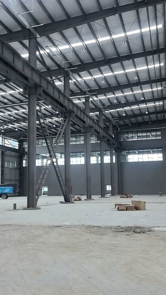 Vista en perspectiva de vigas carril e iluminación en estructuras metálicas para bodegas.