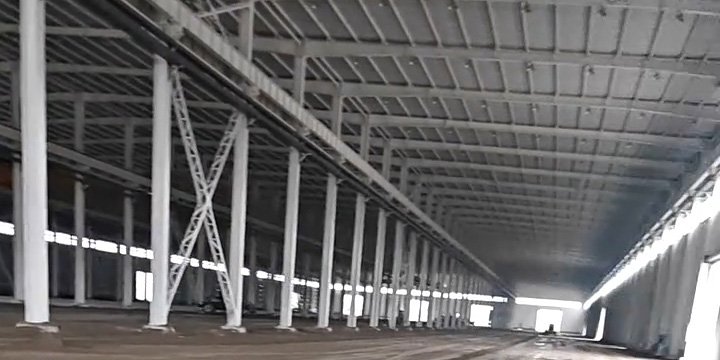Interior de galpón metálico prefabricado con estructura de acero y suelo en preparación antes de su utilización.
