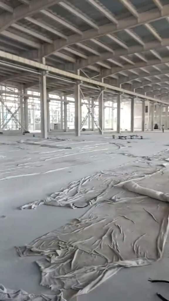 Galpón prefabricado de acero en proceso de montaje con piso protegido.