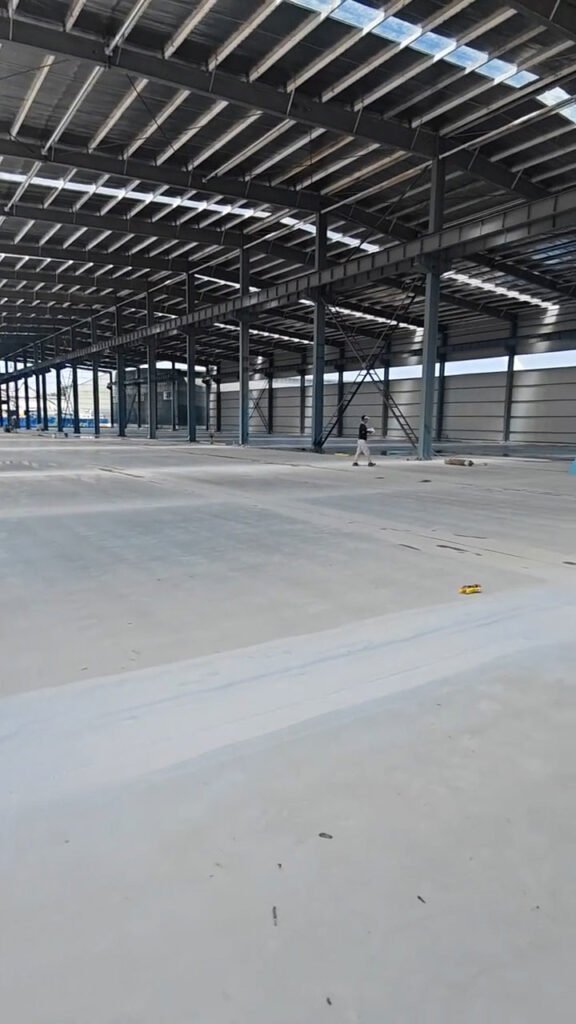 Sombra proyectada por columnas y correas metálicas en galpón prefabricado.