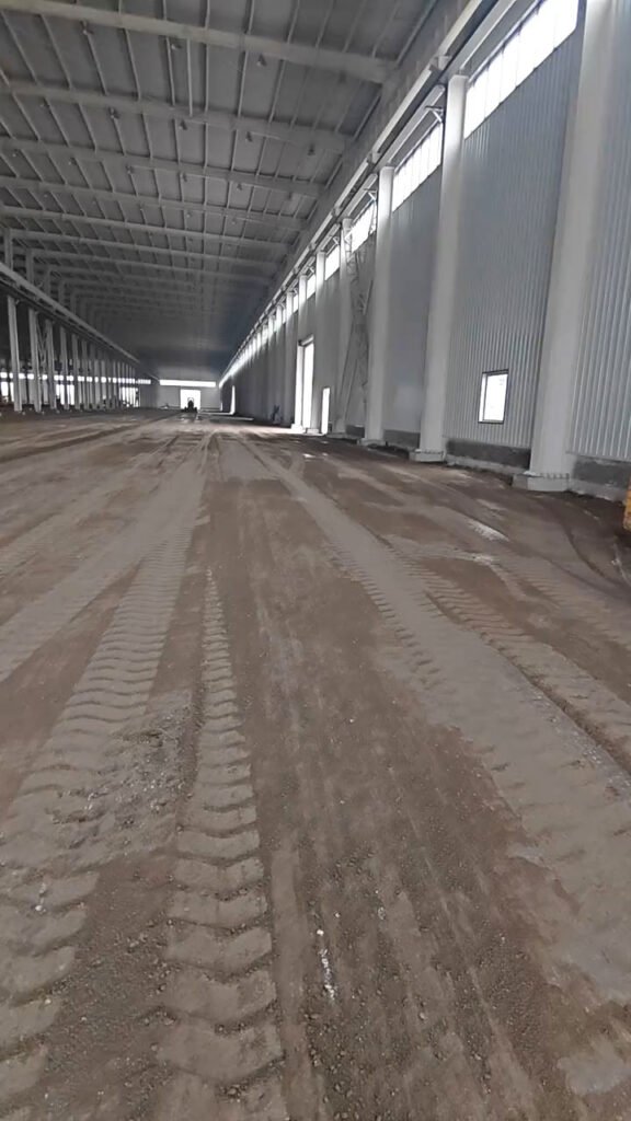Interior de galpón industrial prefabricado con columnas de acero, cubierta metálica y amplio espacio de trabajo.