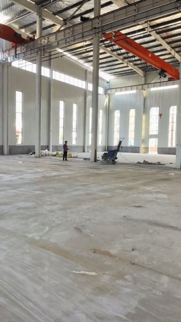 Puente grúa instalado en la parte superior de galpones industriales de gran altura.