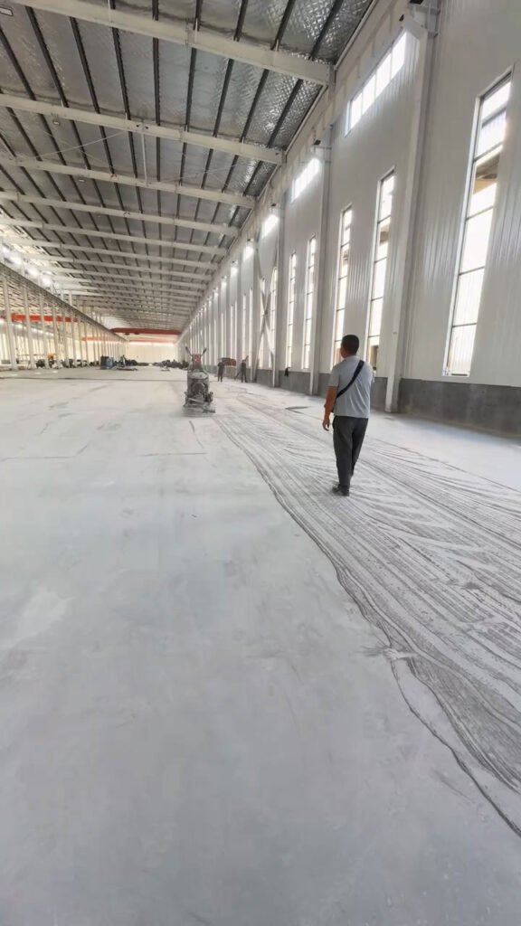 Fachada e interior espacioso de galpones con cerramiento en panel sándwich y piso de concreto.
