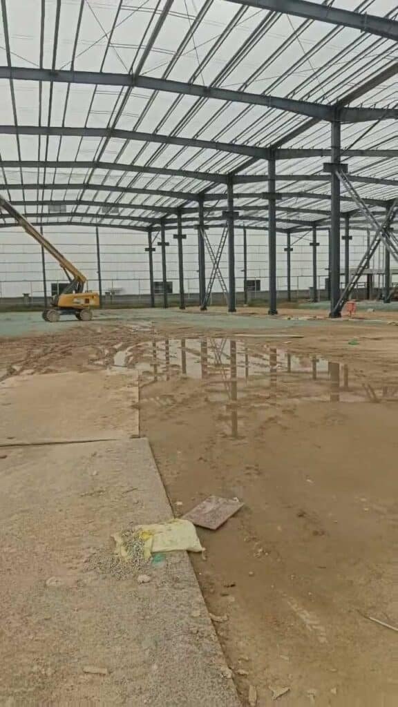 Proceso constructivo de estructura metálica evaluando terreno y cimentación para ensamblaje final.