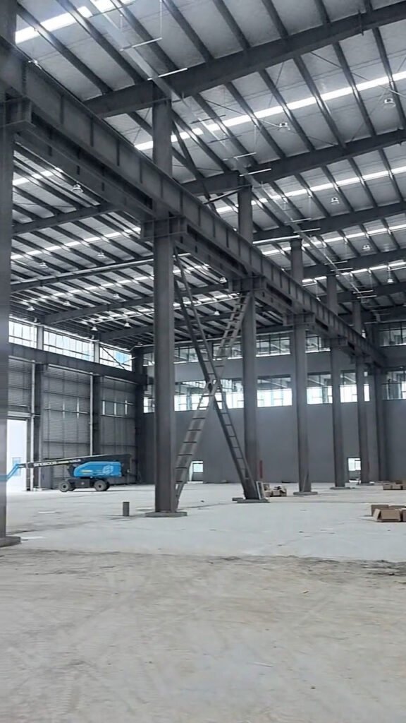 Interior amplio de una bodega prefabricada mostrando columnas y vigas de gran luz libre.
