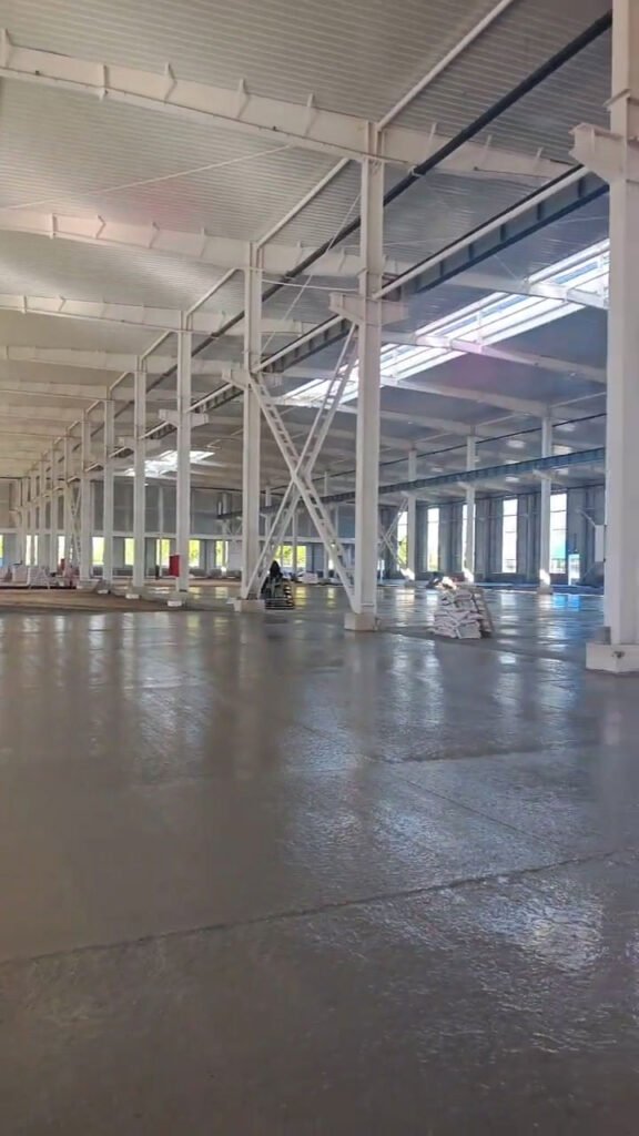 Industrial portal frame structural layout with white painted H-section steel columns.