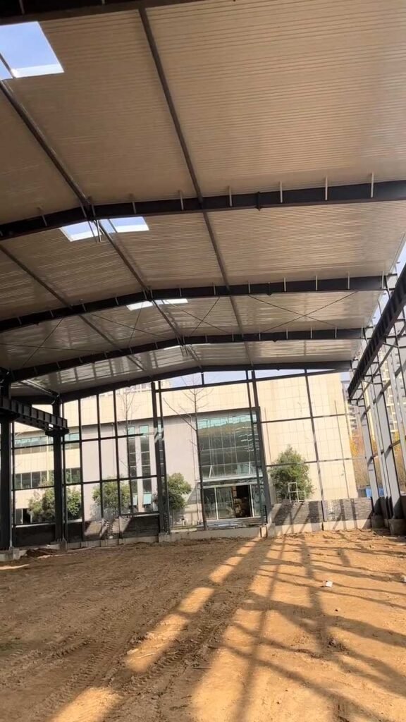 Estructura de cubierta metálica de un galpón prefabricado con paneles de techo y franjas de iluminación natural.
