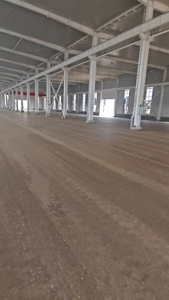 Vigas de acero y marcos principales instalados en un almacén con perfiles de acero estructural.